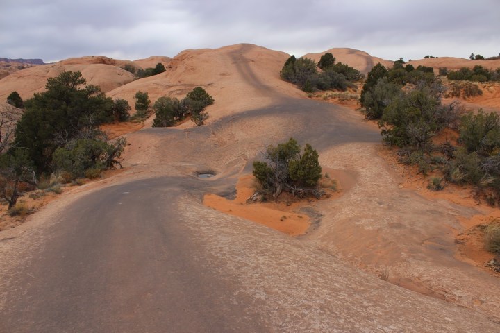 a person riding a bike down a dirt road